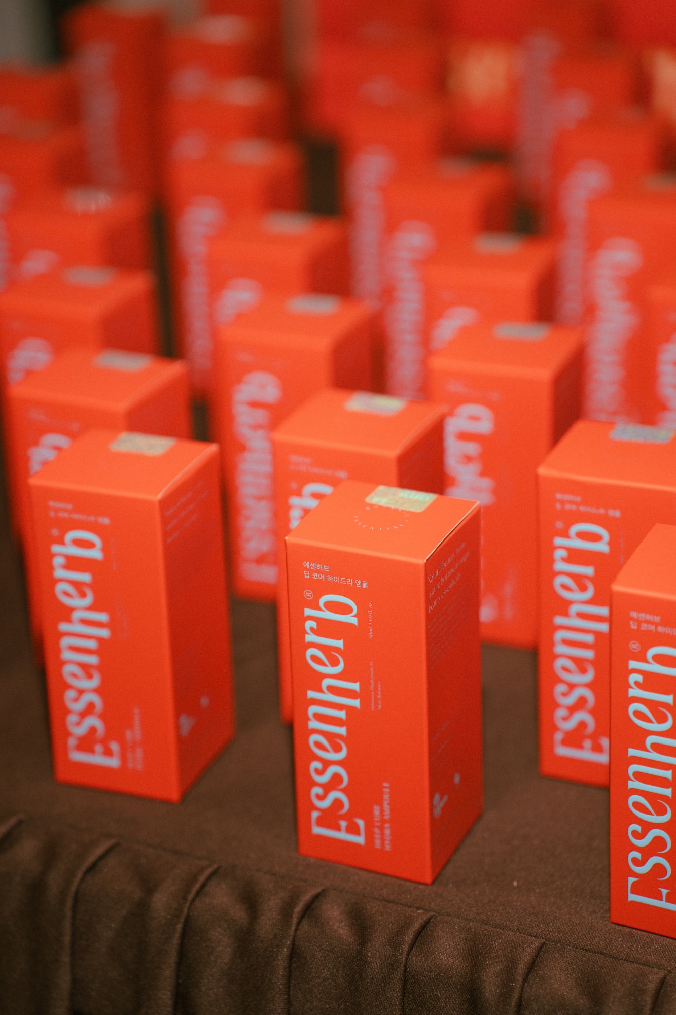 Rows of product boxes lined up on the brown draped table