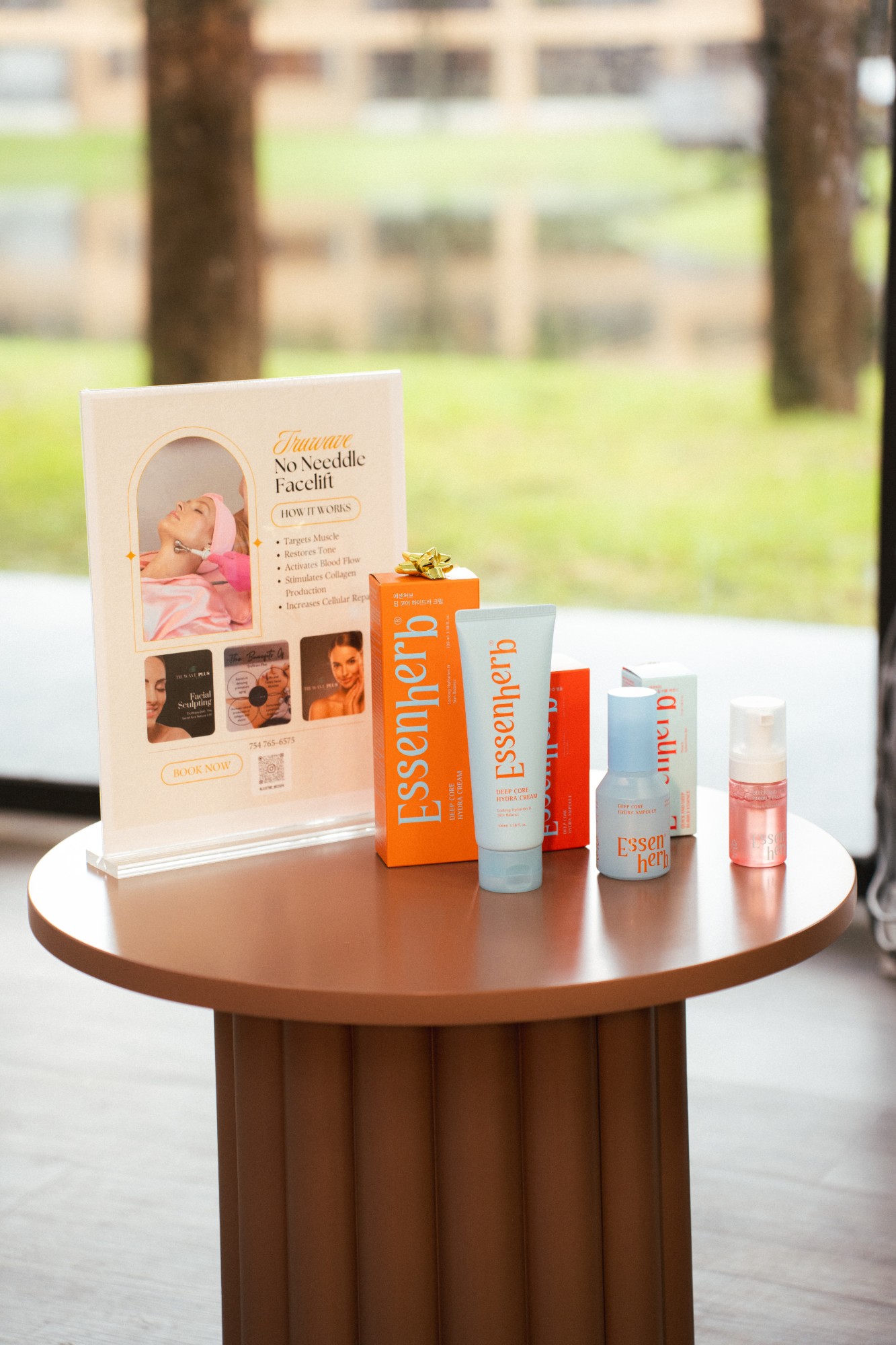 Truwave No Needle Facelift booking sign on a side table with skincare