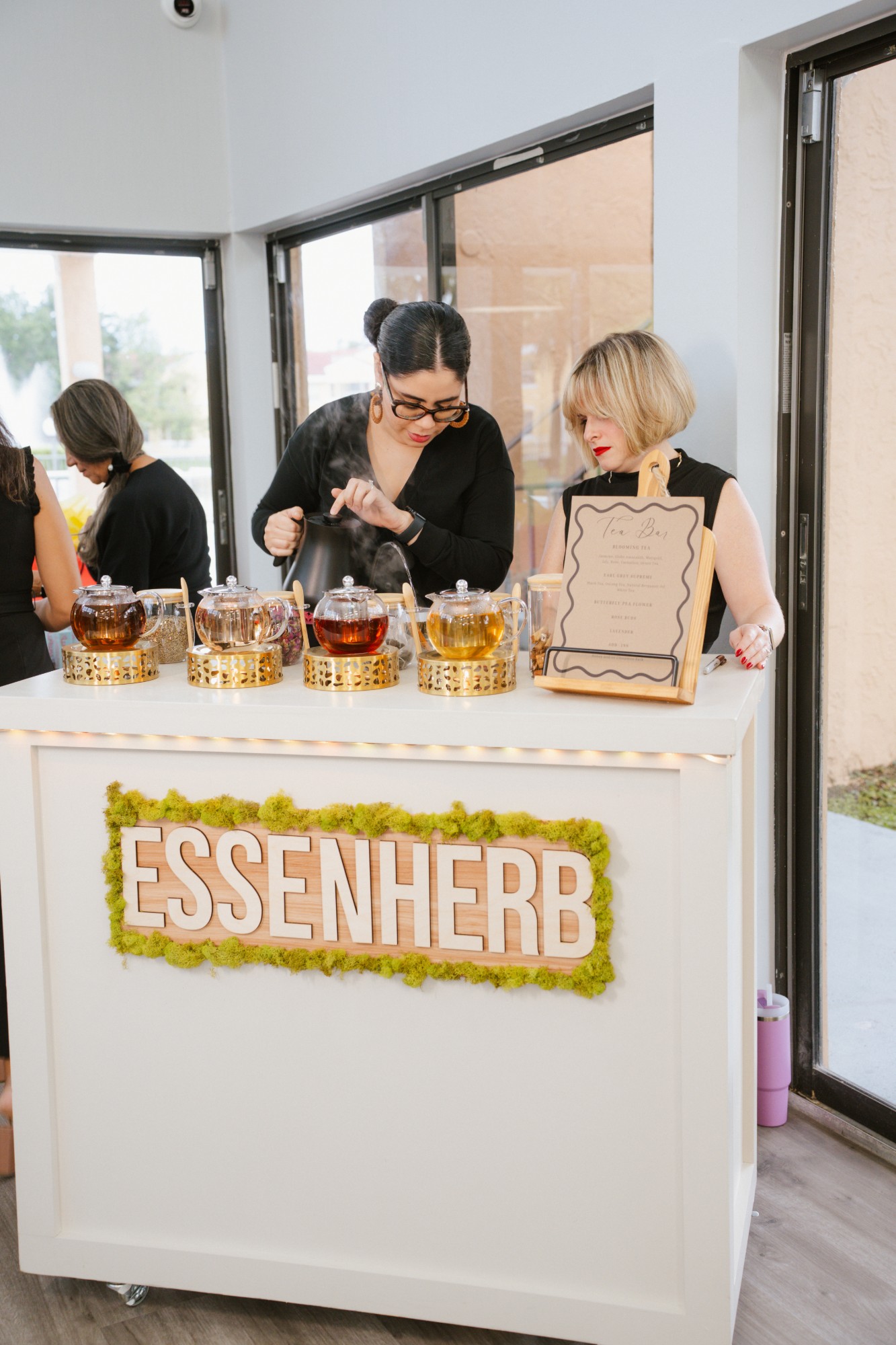 Live tea bar with baristas pouring blooming tea