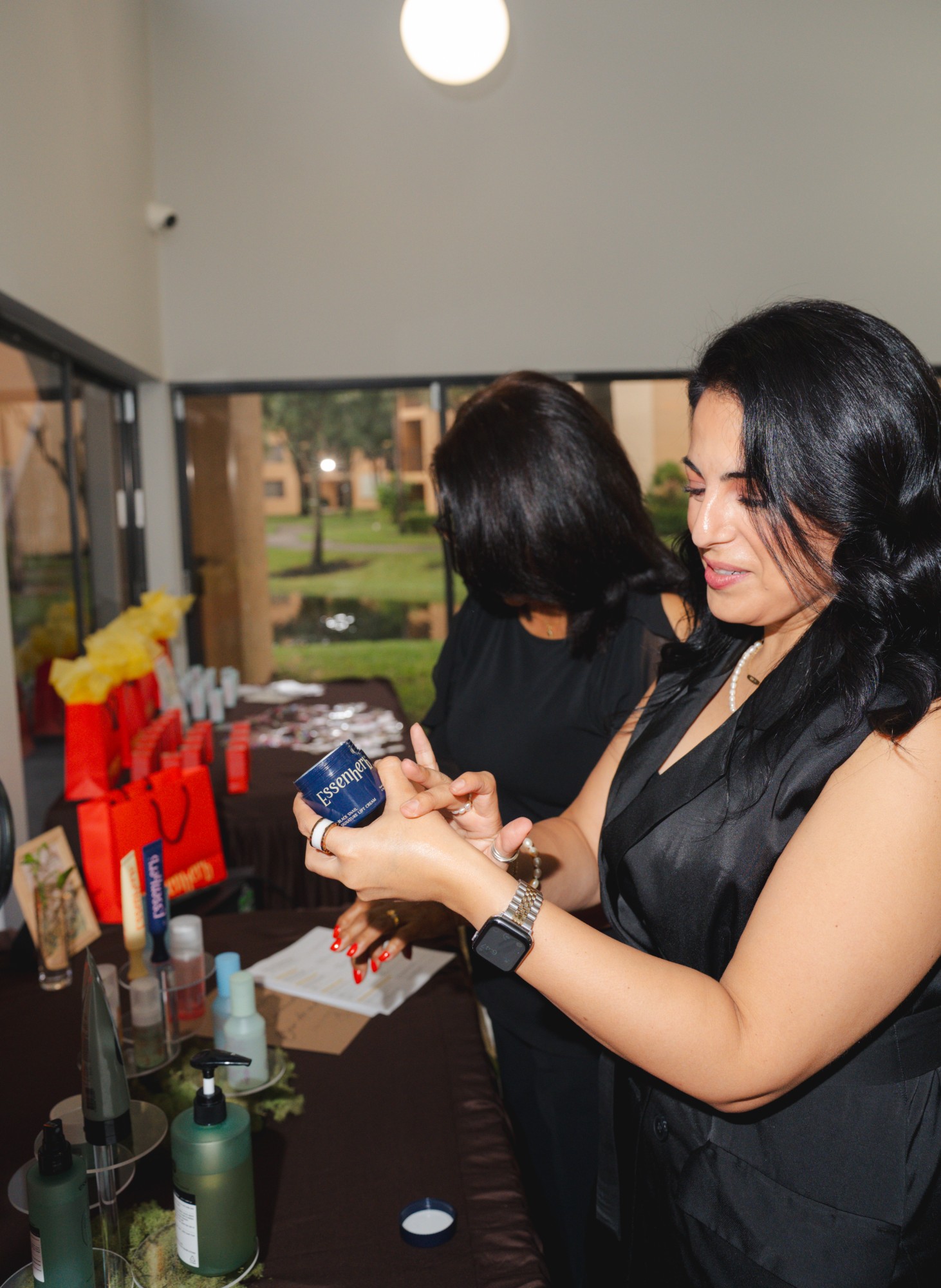 Guest testing the black snail cream on her hand at the product table