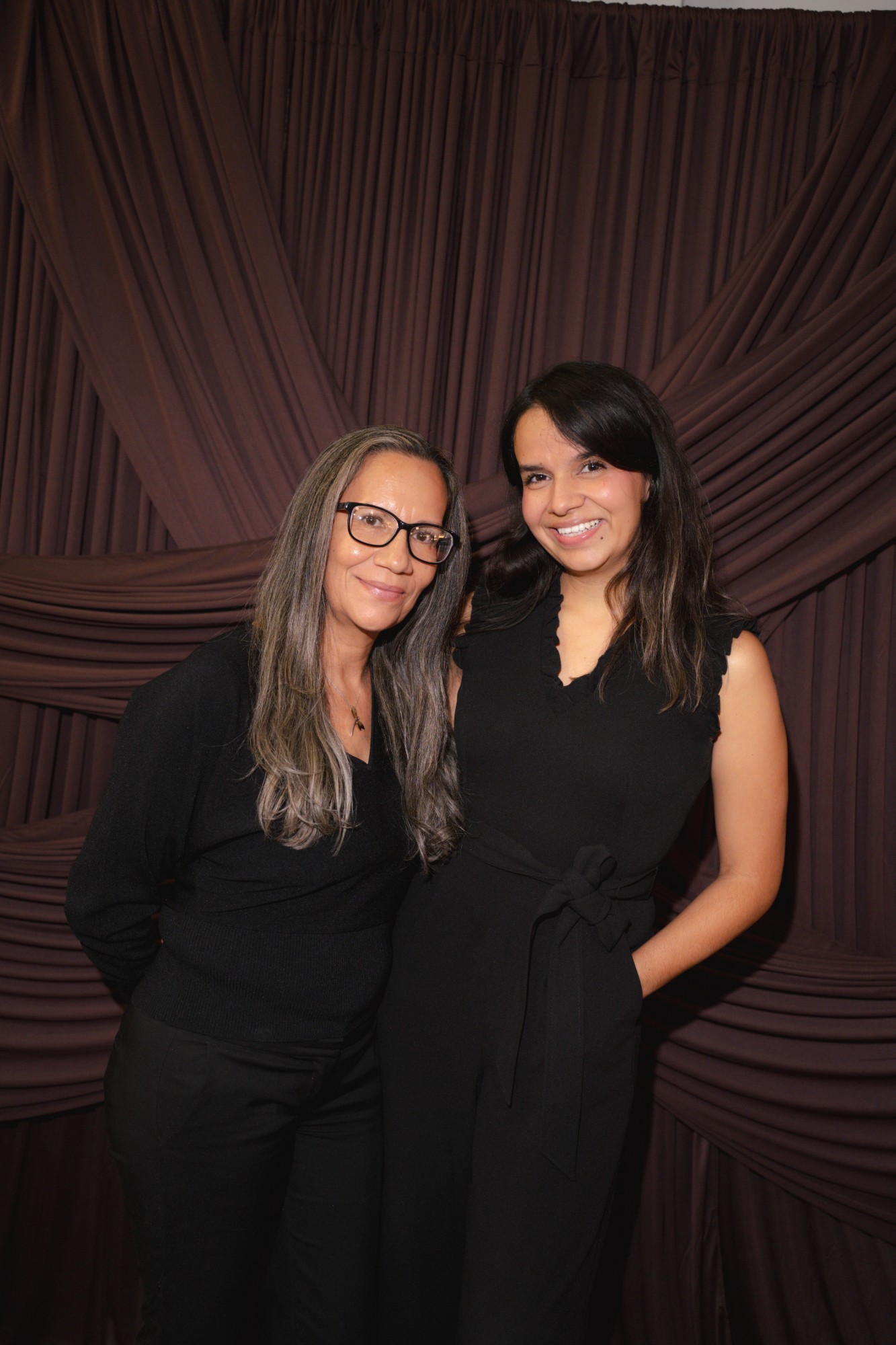Two guests posing together at the photobooth backdrop