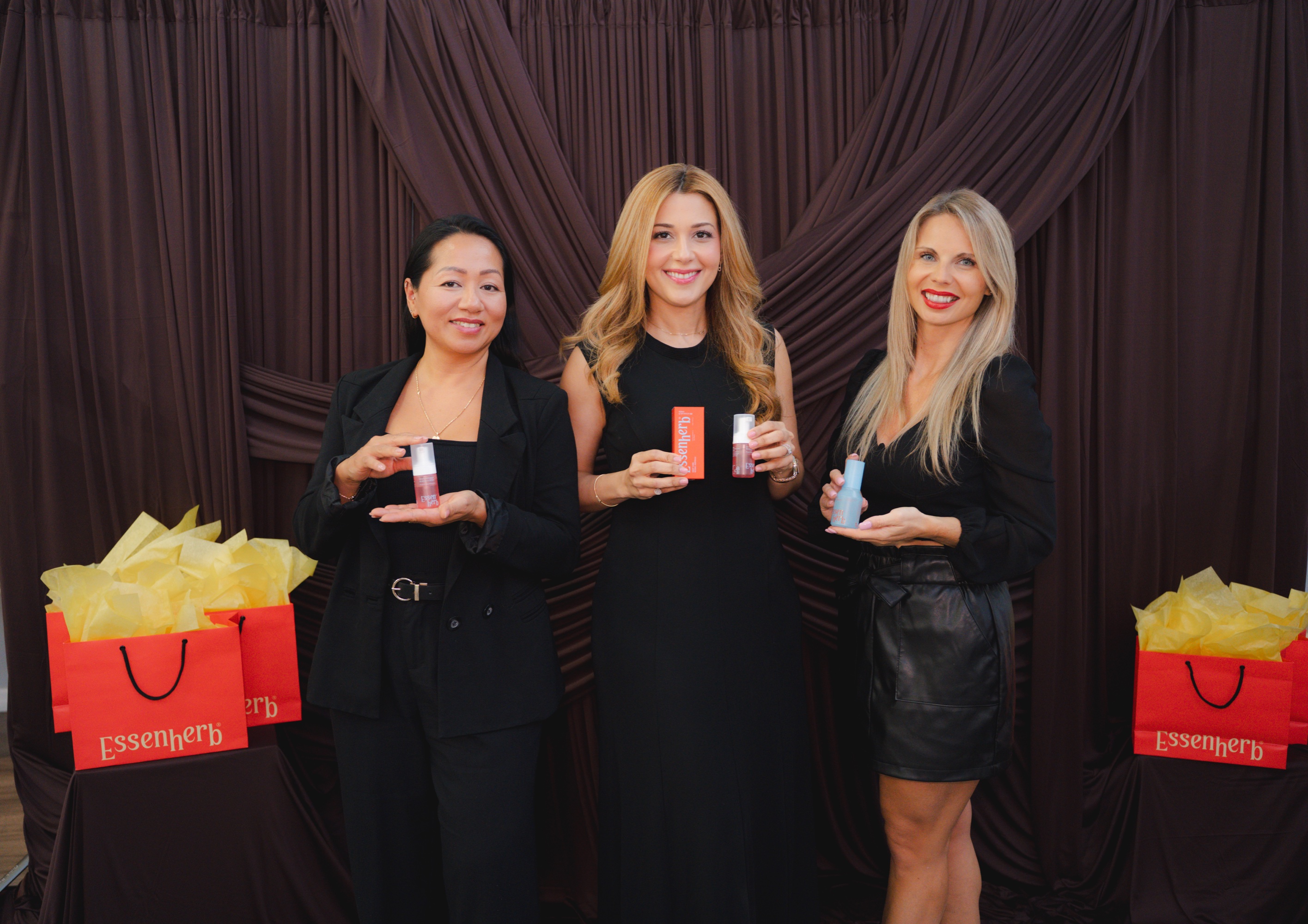 Three guests posing together at the photobooth backdrop