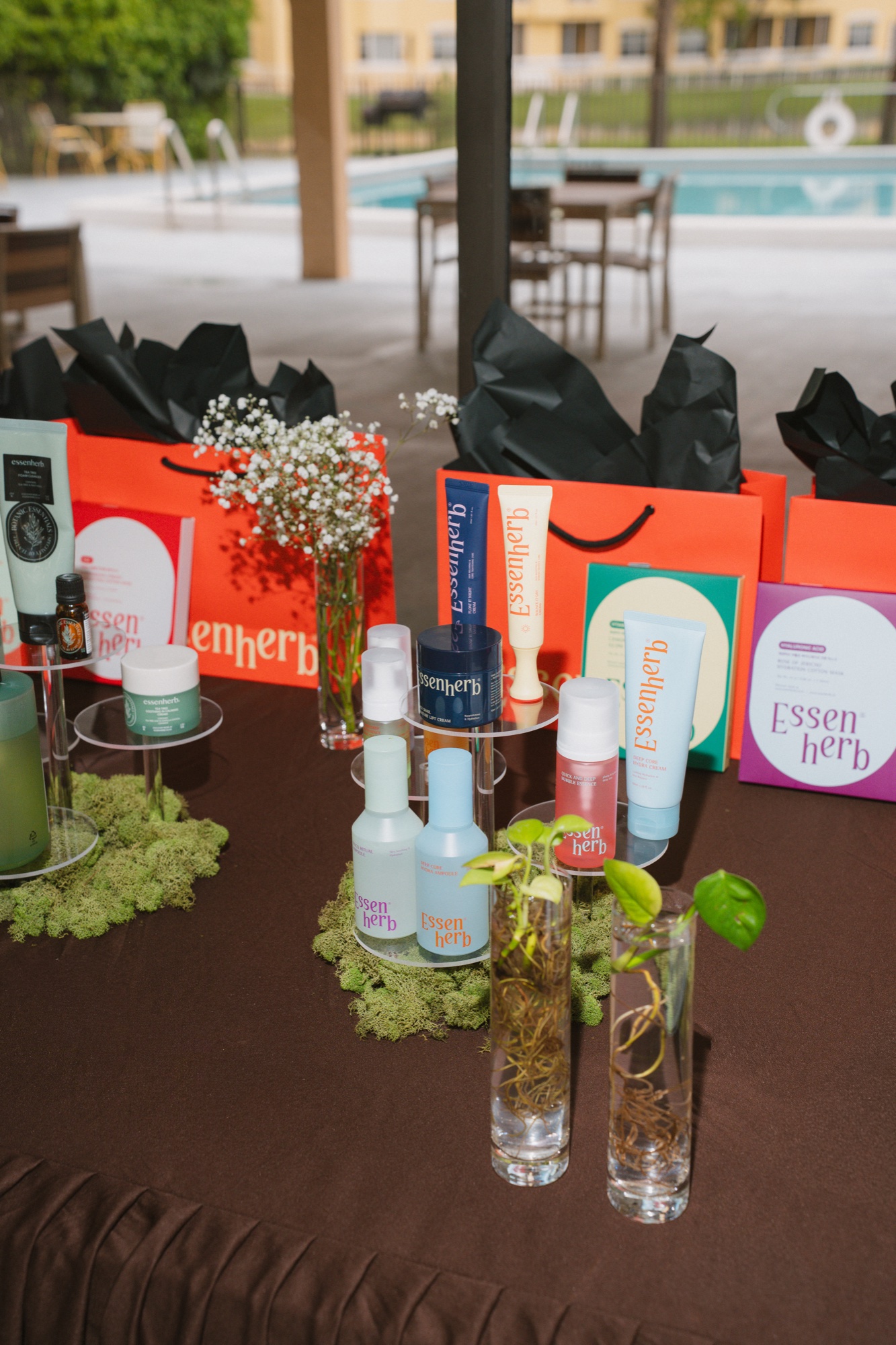 Skincare product display on moss with pool backdrop