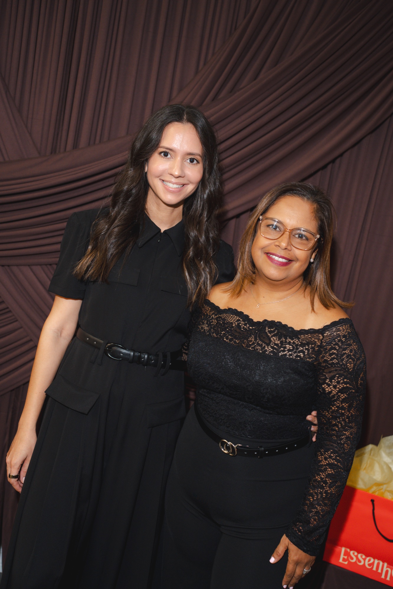 Two guests posing together at the photobooth backdrop